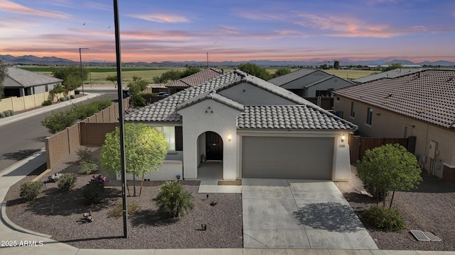 19203 W Jackson St, Buckeye, AZ 85326 - mediterranean / spanish house featuring a garage, a tile roof, fence, stucco siding, and driveway