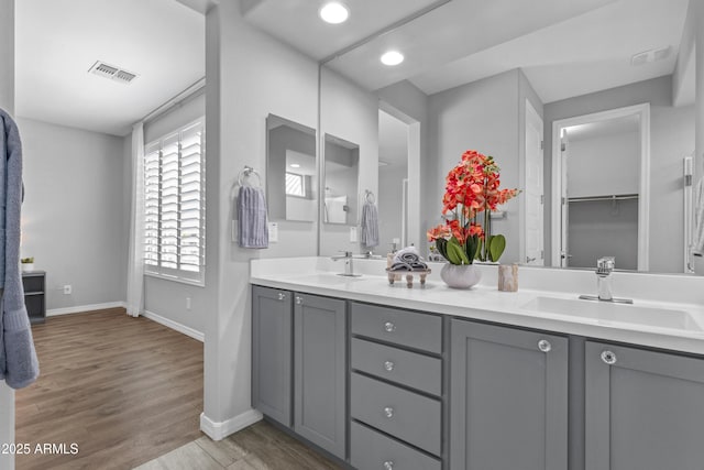 19203 W Jackson St, Buckeye, AZ 85326 - bathroom with baseboards, wood finished floors, double vanity, recessed lighting, and a walk in closet