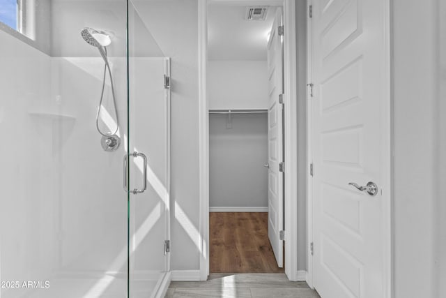 19203 W Jackson St, Buckeye, AZ 85326 - bathroom with a stall shower, wood finished floors, and baseboards