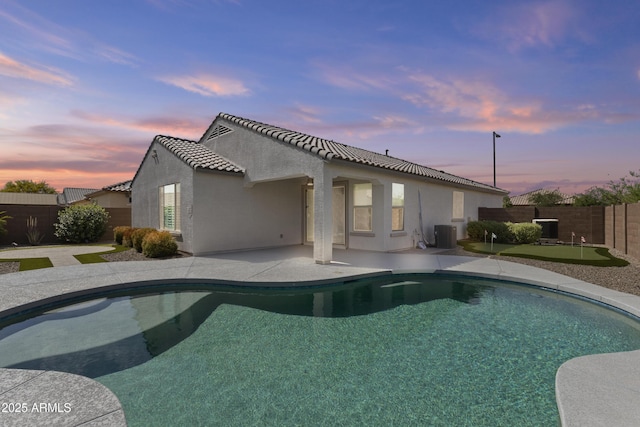 19203 W Jackson St, Buckeye, AZ 85326 - back of property at dusk with a fenced backyard, stucco siding, a patio area, and central AC