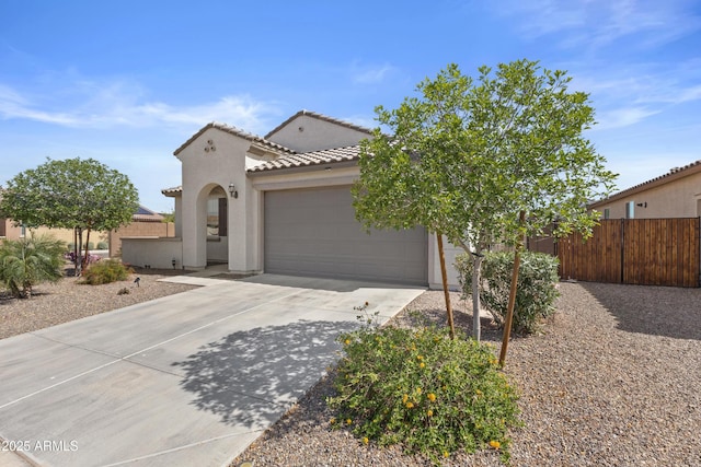 19203 W Jackson St, Buckeye, AZ 85326 - mediterranean / spanish-style house with stucco siding, an attached garage, fence, concrete driveway, and a tiled roof
