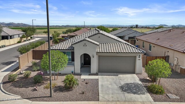 19203 W Jackson St, Buckeye, AZ 85326 - mediterranean / spanish-style home with a garage, a tile roof, fence, stucco siding, and driveway