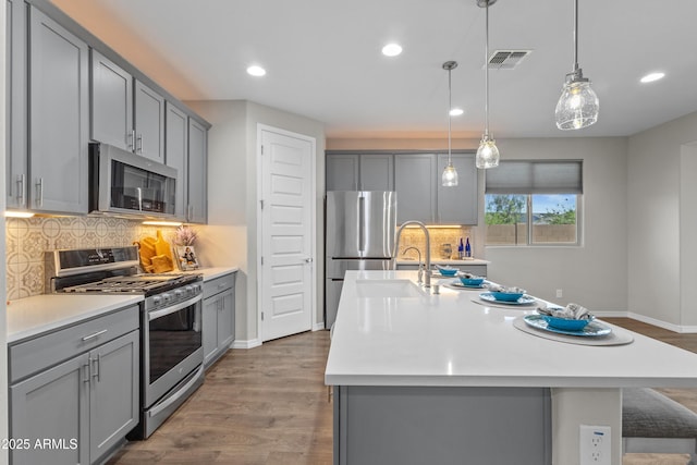 19203 W Jackson St, Buckeye, AZ 85326 - kitchen featuring appliances with stainless steel finishes, gray cabinetry, light countertops, and recessed lighting