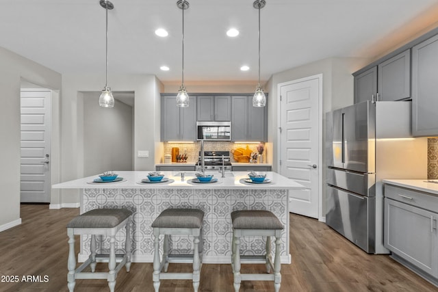 19203 W Jackson St, Buckeye, AZ 85326 - kitchen with stainless steel appliances, gray cabinetry, decorative backsplash, light countertops, and baseboards