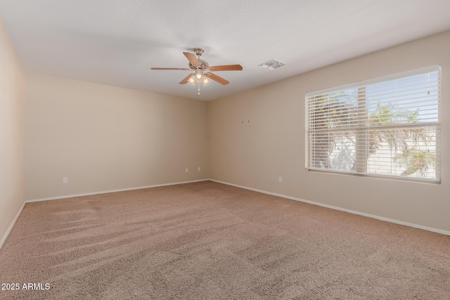 empty room with visible vents, baseboards, a ceiling fan, and carpet floors