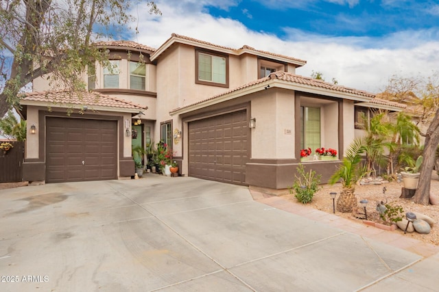 mediterranean / spanish house featuring a garage, concrete driveway, a tile roof, and stucco siding