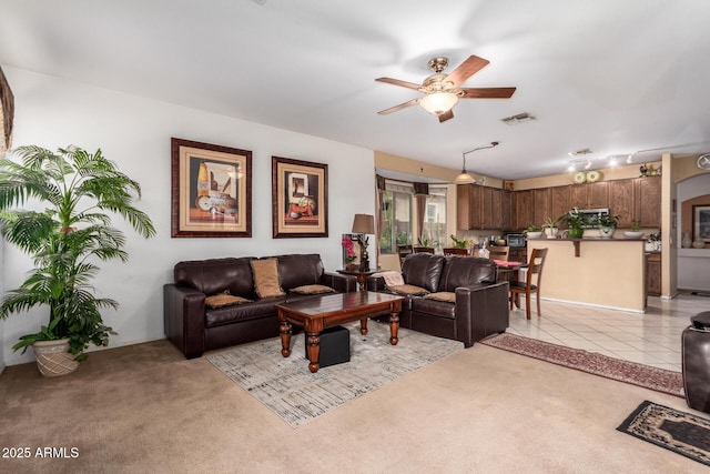 living room with light carpet, ceiling fan, light tile patterned floors, and visible vents