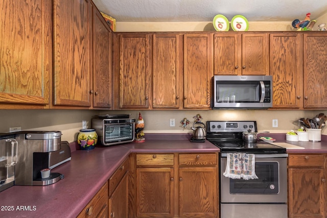 kitchen featuring appliances with stainless steel finishes and brown cabinets