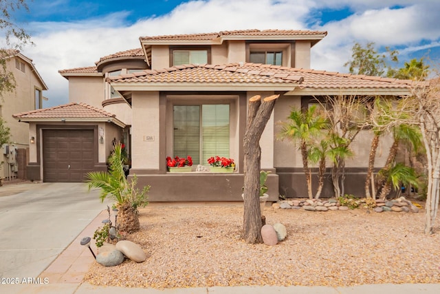 mediterranean / spanish house with a garage, concrete driveway, and stucco siding