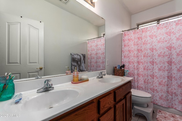 full bathroom featuring double vanity, tile patterned flooring, toilet, and a sink