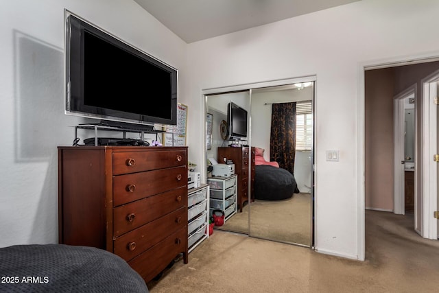 bedroom with light carpet, a closet, and baseboards