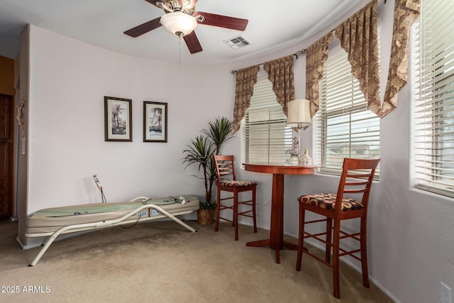 living area featuring baseboards, visible vents, ceiling fan, and carpet flooring