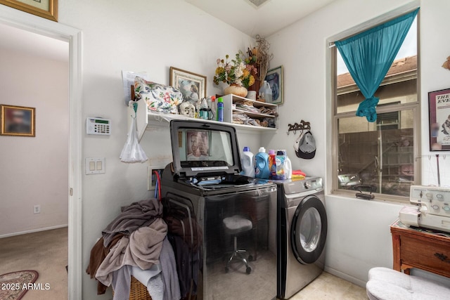 clothes washing area featuring laundry area, separate washer and dryer, and baseboards