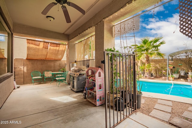 view of swimming pool featuring a ceiling fan, a fenced in pool, a patio, a grill, and fence