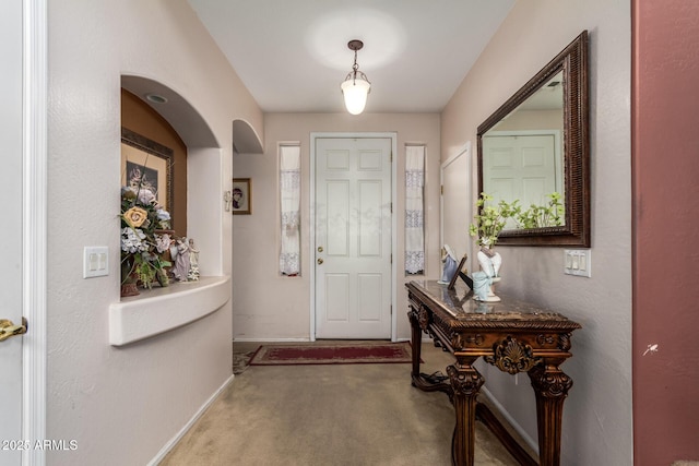 carpeted foyer entrance with baseboards