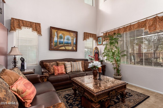 living room with carpet floors and a towering ceiling