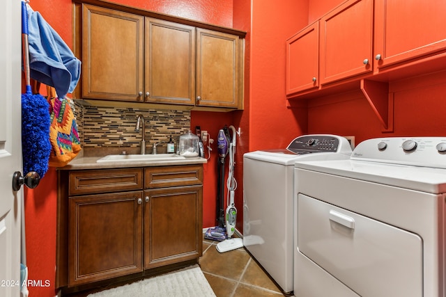 laundry area featuring tile patterned flooring, sink, cabinets, and washing machine and clothes dryer