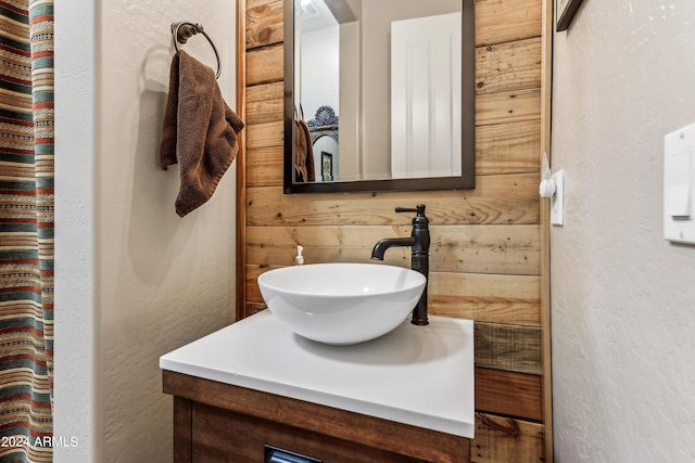 bathroom featuring vanity and wood walls