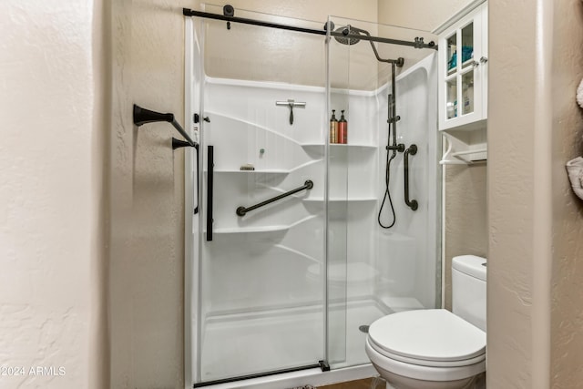 bathroom featuring an enclosed shower and toilet