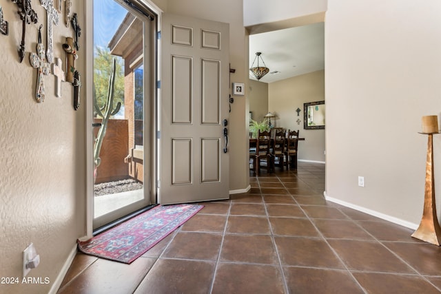 entryway with dark tile patterned flooring