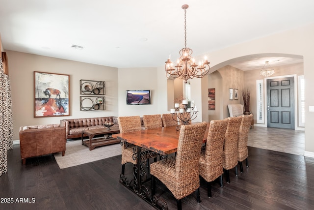 5428 E Windstone Trl, Cave Creek, AZ 85331 - dining area featuring a chandelier, arched walkways, dark wood-style floors, and baseboards