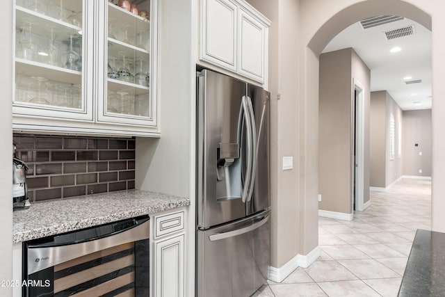 5428 E Windstone Trl, Cave Creek, AZ 85331 - kitchen featuring stainless steel fridge, wine cooler, arched walkways, backsplash, and baseboards