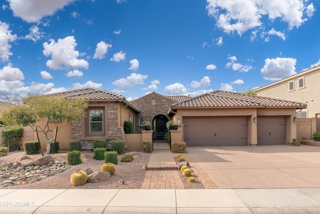 5428 E Windstone Trl, Cave Creek, AZ 85331 - mediterranean / spanish house with an attached garage, stucco siding, stone siding, and driveway