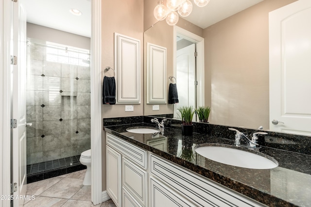 5428 E Windstone Trl, Cave Creek, AZ 85331 - bathroom with toilet, double vanity, a tile shower, tile patterned floors, and a chandelier