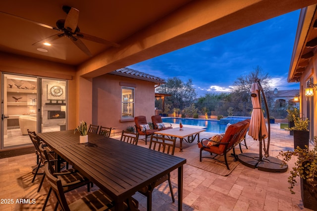 5428 E Windstone Trl, Cave Creek, AZ 85331 - patio terrace at dusk featuring a patio, ceiling fan, outdoor dining area, and a pool with connected hot tub