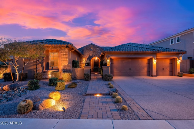 5428 E Windstone Trl, Cave Creek, AZ 85331 - view of front of property featuring stone siding, an attached garage, driveway, a tiled roof, and a gate