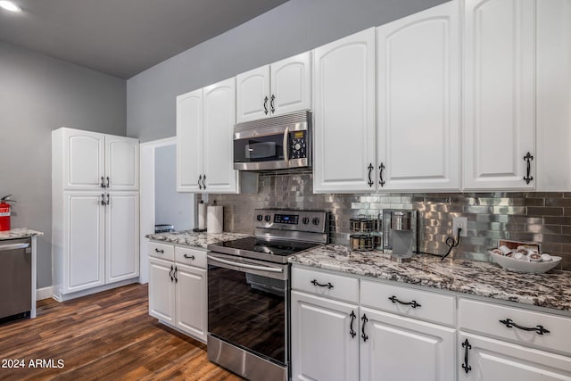 kitchen with appliances with stainless steel finishes, dark hardwood / wood-style flooring, and white cabinets