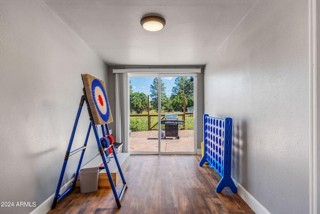 rec room with a textured ceiling and dark hardwood / wood-style floors