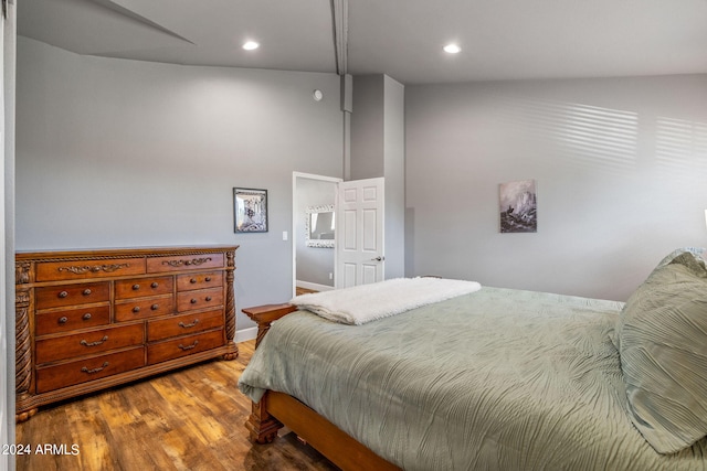 bedroom featuring high vaulted ceiling and wood-type flooring