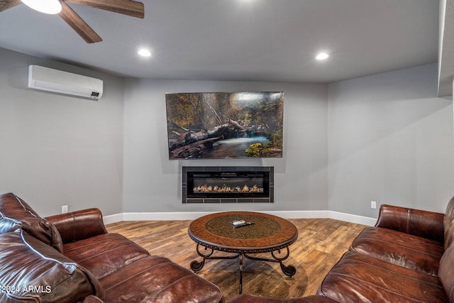 living room with hardwood / wood-style flooring, an AC wall unit, and ceiling fan