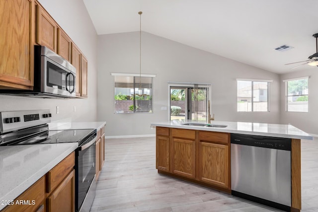 13020 W Highland Ave, Litchfield Park, AZ 85340 - kitchen with stainless steel appliances, vaulted ceiling, light wood-style floors, plenty of natural light, and brown cabinets