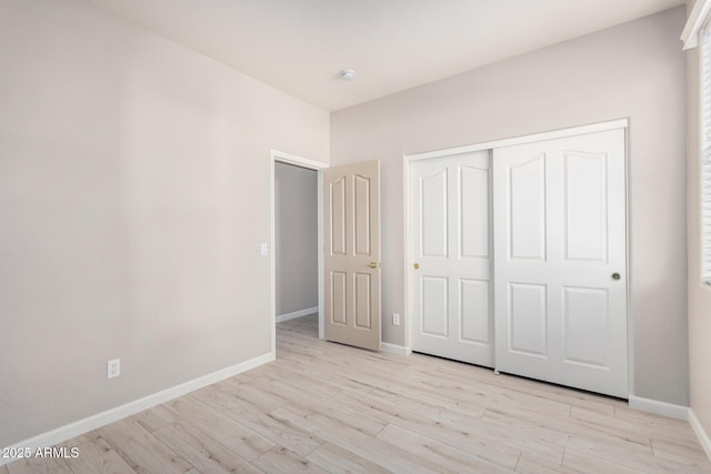 13020 W Highland Ave, Litchfield Park, AZ 85340 - unfurnished bedroom with light wood-style floors and a closet