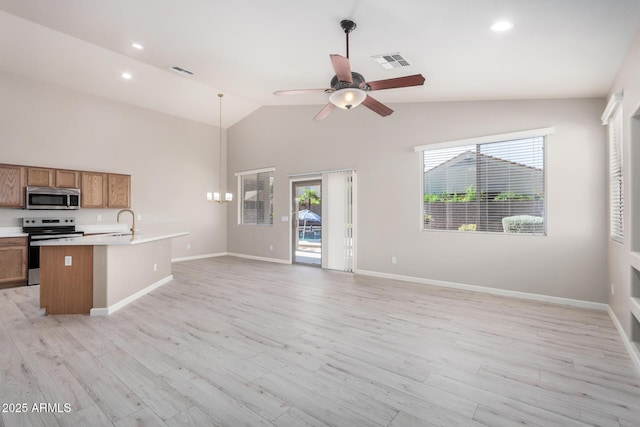 13020 W Highland Ave, Litchfield Park, AZ 85340 - kitchen with stainless steel appliances, brown cabinets, open floor plan, light countertops, and light wood-style flooring