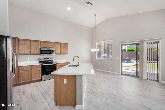 13020 W Highland Ave, Litchfield Park, AZ 85340 - kitchen with stainless steel appliances, high vaulted ceiling, brown cabinets, and light wood-type flooring