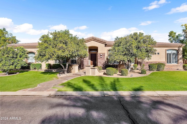 mediterranean / spanish house with a front yard