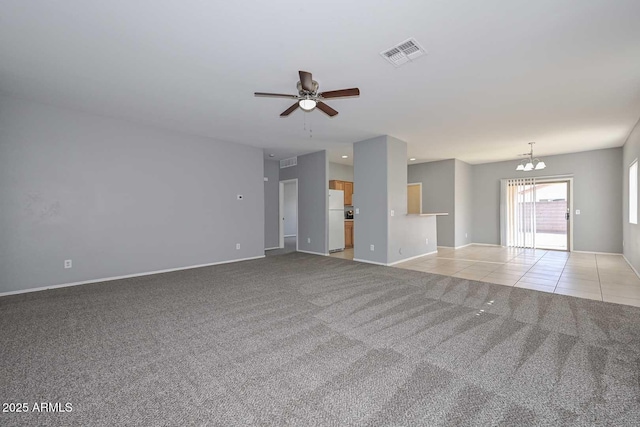 unfurnished living room featuring light carpet and ceiling fan with notable chandelier