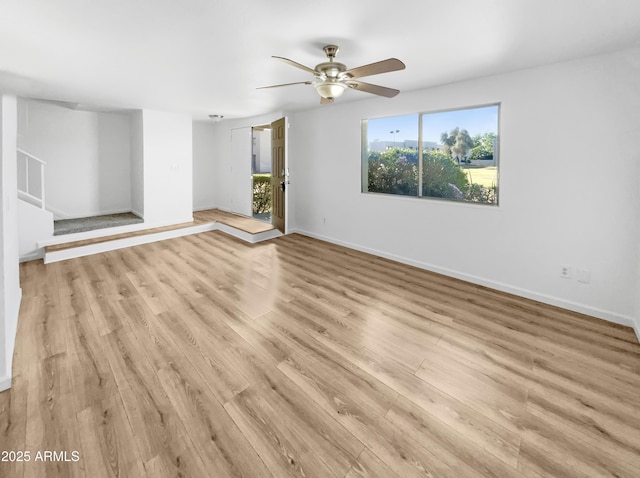 225 N Standage Unit 89, Mesa, AZ 85201 - unfurnished living room with light wood-type flooring, a ceiling fan, stairs, and baseboards