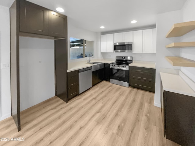 225 N Standage Unit 89, Mesa, AZ 85201 - kitchen with a sink, light wood-style floors, light countertops, white cabinets, and appliances with stainless steel finishes