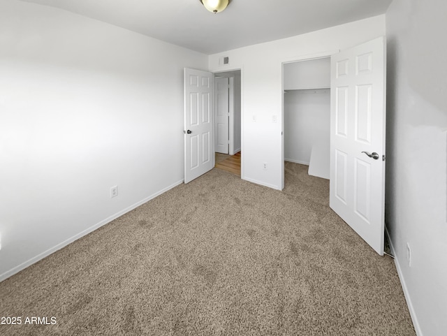 225 N Standage Unit 89, Mesa, AZ 85201 - unfurnished bedroom with a walk in closet, a closet, carpet flooring, and baseboards