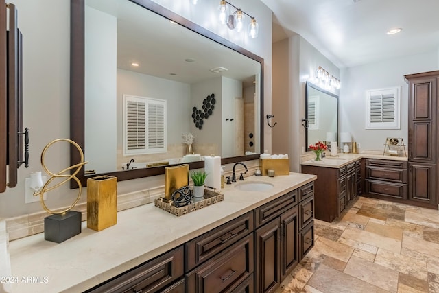 1409 E Dove Pl, Casa Grande, AZ 85122 - full bath featuring two vanities, stone tile flooring, recessed lighting, a shower, and a bath