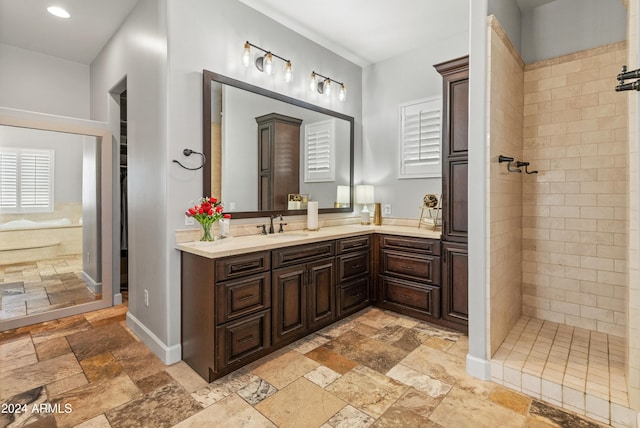 1409 E Dove Pl, Casa Grande, AZ 85122 - bathroom featuring stone tile floors, vanity, a tile shower, and recessed lighting