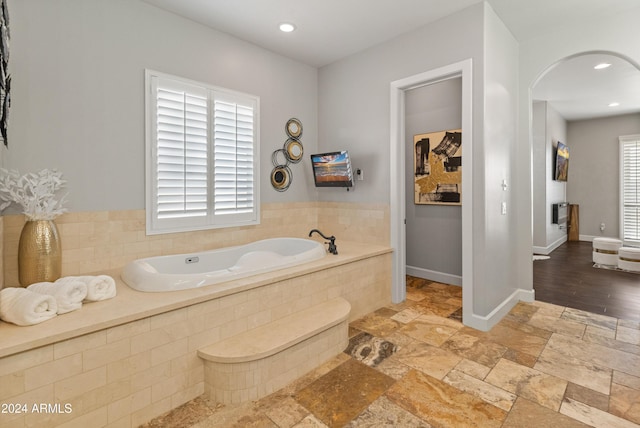 1409 E Dove Pl, Casa Grande, AZ 85122 - bathroom featuring a garden tub, recessed lighting, stone tile flooring, and baseboards