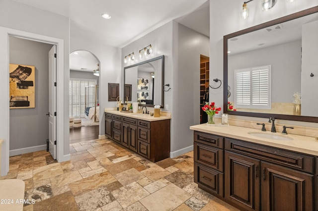 1409 E Dove Pl, Casa Grande, AZ 85122 - full bathroom featuring stone tile flooring, two vanities, baseboards, healthy amount of natural light, and recessed lighting