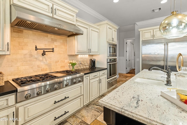 1409 E Dove Pl, Casa Grande, AZ 85122 - kitchen with cream cabinets, range hood, stainless steel appliances, a sink, and a warming drawer