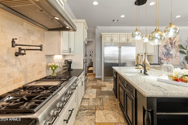 1409 E Dove Pl, Casa Grande, AZ 85122 - kitchen featuring wall chimney range hood, appliances with stainless steel finishes, stone tile floors, light stone countertops, and decorative backsplash