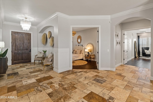 1409 E Dove Pl, Casa Grande, AZ 85122 - foyer with stone tile floors, crown molding, arched walkways, a chandelier, and wainscoting